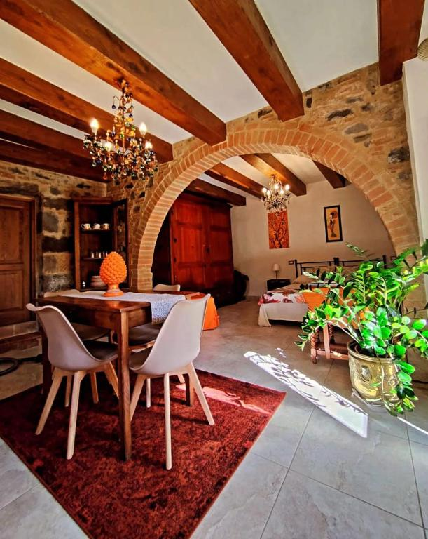 Sala da pranzo con archi in mattoni, travi in legno e lampadario artigianale